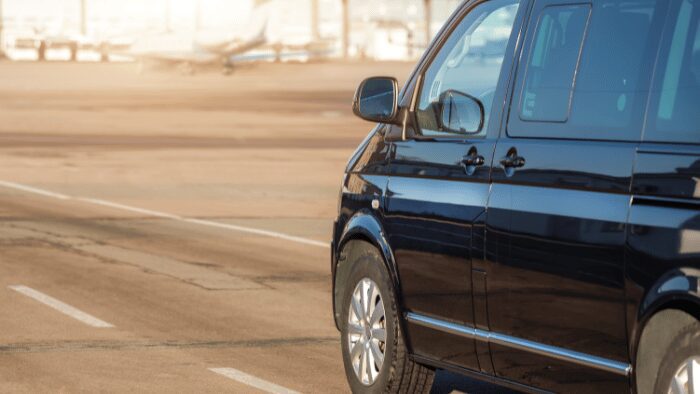 Luxury black minivan waiting at Santorini Airport for a private transfer pickup, symbolizing comfort and professionalism for arriving travelers.