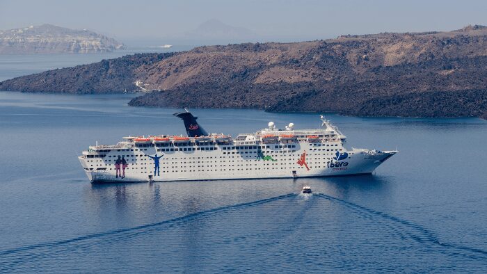 Cruise ship arriving at the Santorini caldera, a common entry point for visitors requiring port transfers.