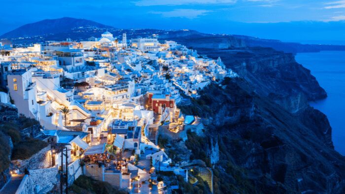 Fira town in Santorini glowing at dusk along the caldera cliffs.
