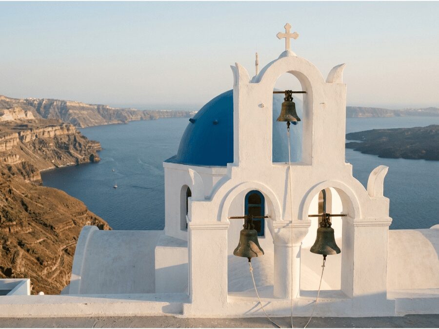Church of the Three Bells in Firostefani Santorini with caldera and Skaros Rock in the background