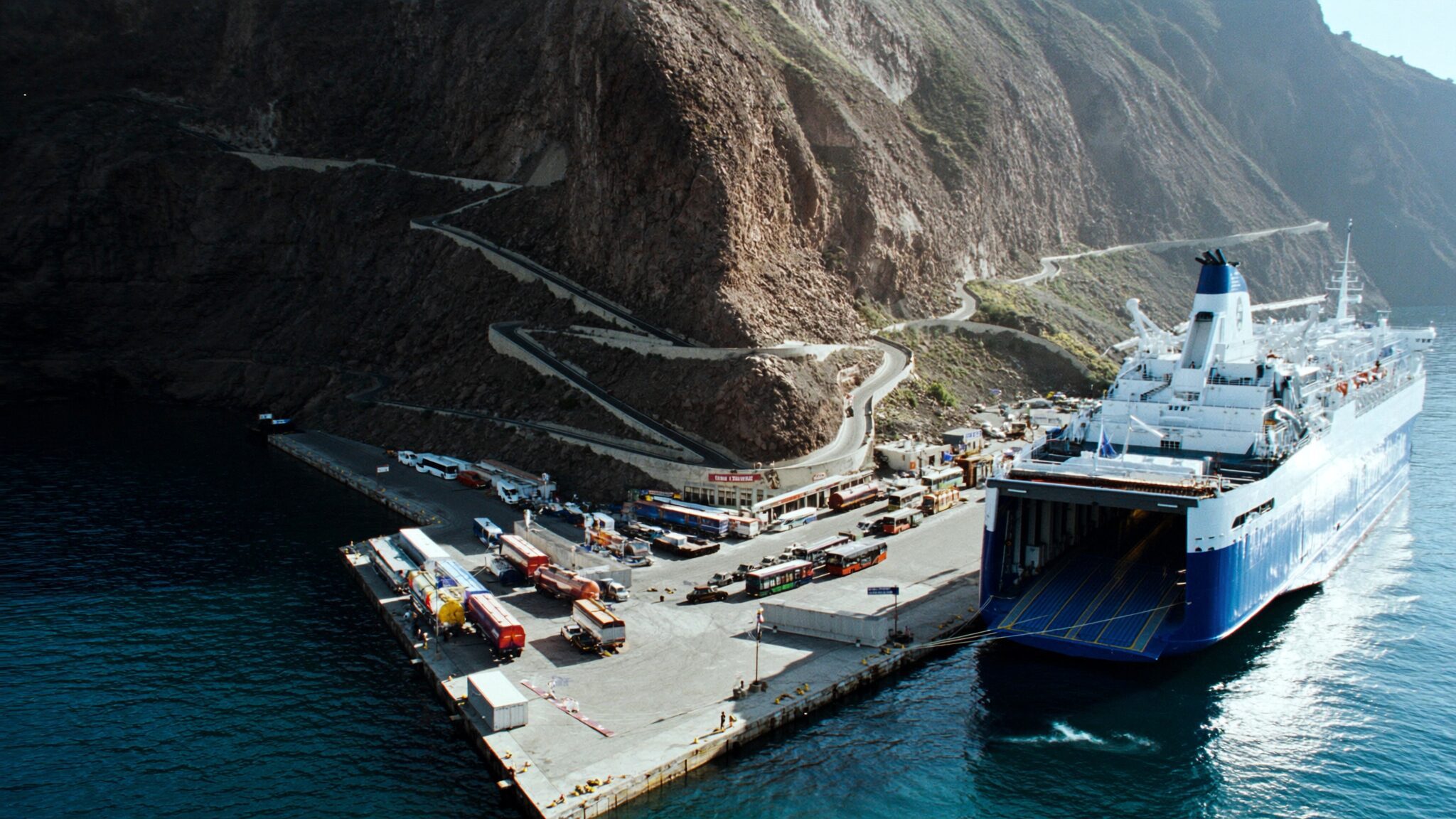 Ferry docked at Athinios Port Santorini below the steep cliff switchback road